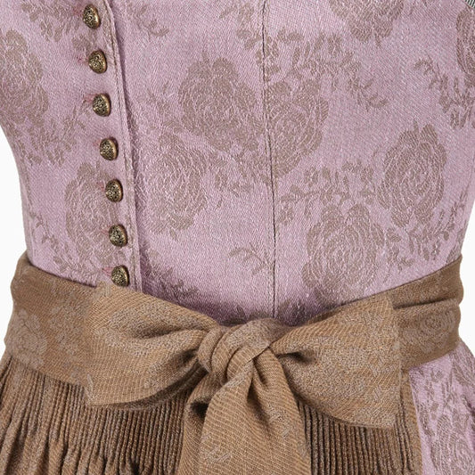 Close-up of a traditional outfit with a patterned top and brown belt.