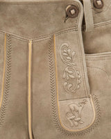 Close-up of brown leather pants with intricate stitching and a embroidered design.