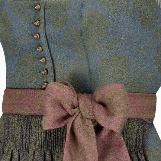 Close-up of a patterned garment with a pink bow and buttons.